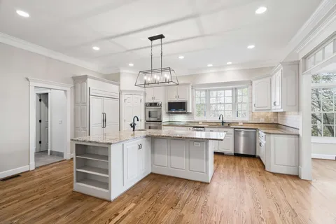 a kitchen with stainless steel appliances granite countertop a sink stove microwave and refrigerator