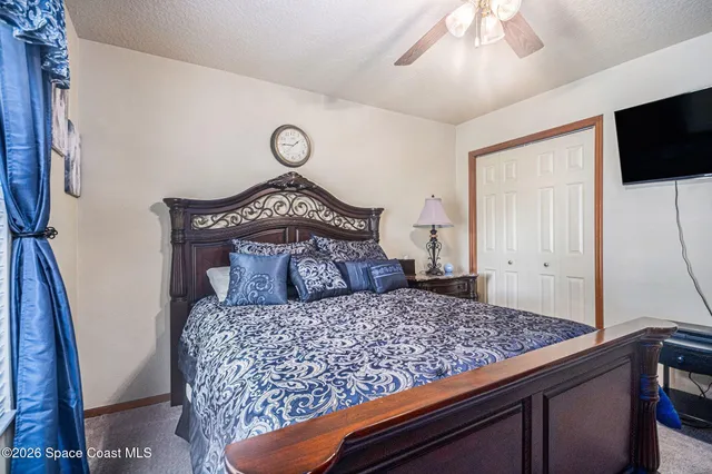 a bedroom with a large bed and a flat tv screen on a dresser