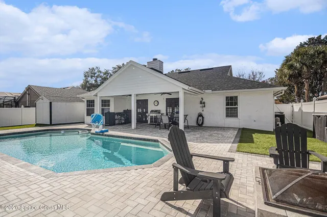 a view of a house with swimming pool and sitting area