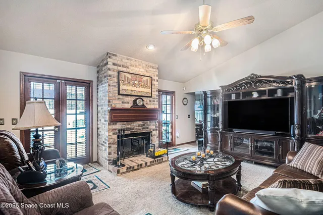 a living room with furniture a flat screen tv and a fireplace