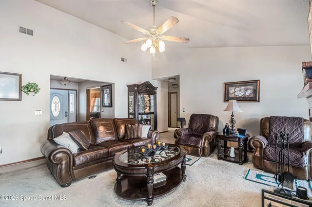 a living room with furniture a chandelier and a window