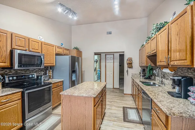 a kitchen with stainless steel appliances granite countertop a stove and a refrigerator