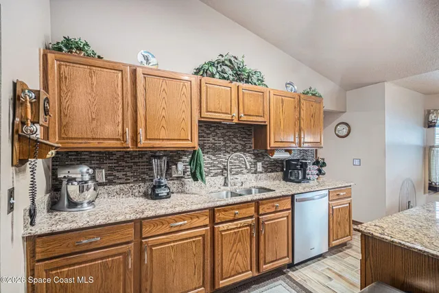 a kitchen with granite countertop a sink stainless steel appliances and cabinets