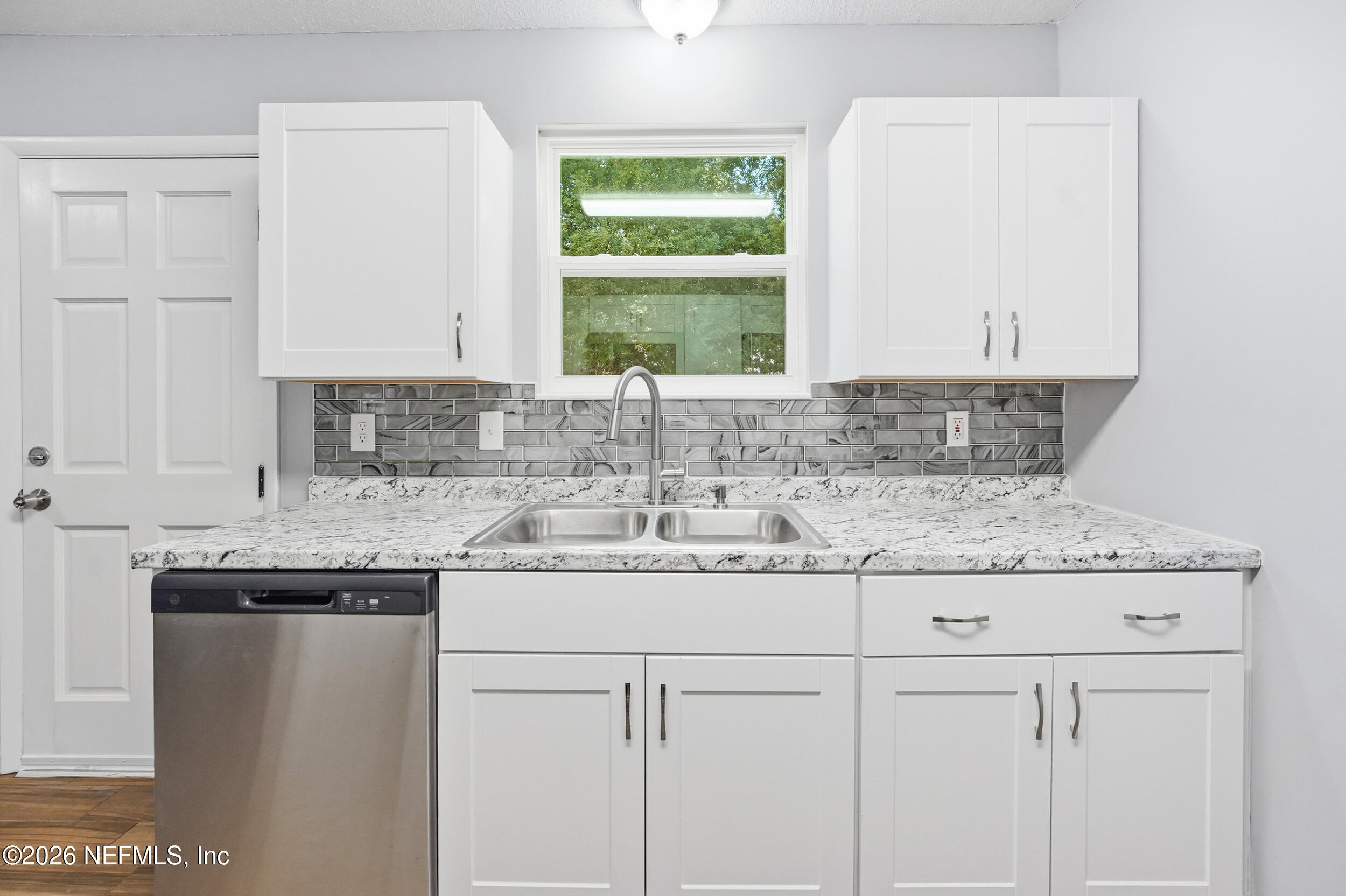3084 Parental Home Road Jacksonville, FL 32216 - Photo 11 of 31 a kitchen with granite countertop white cabinets and a sink