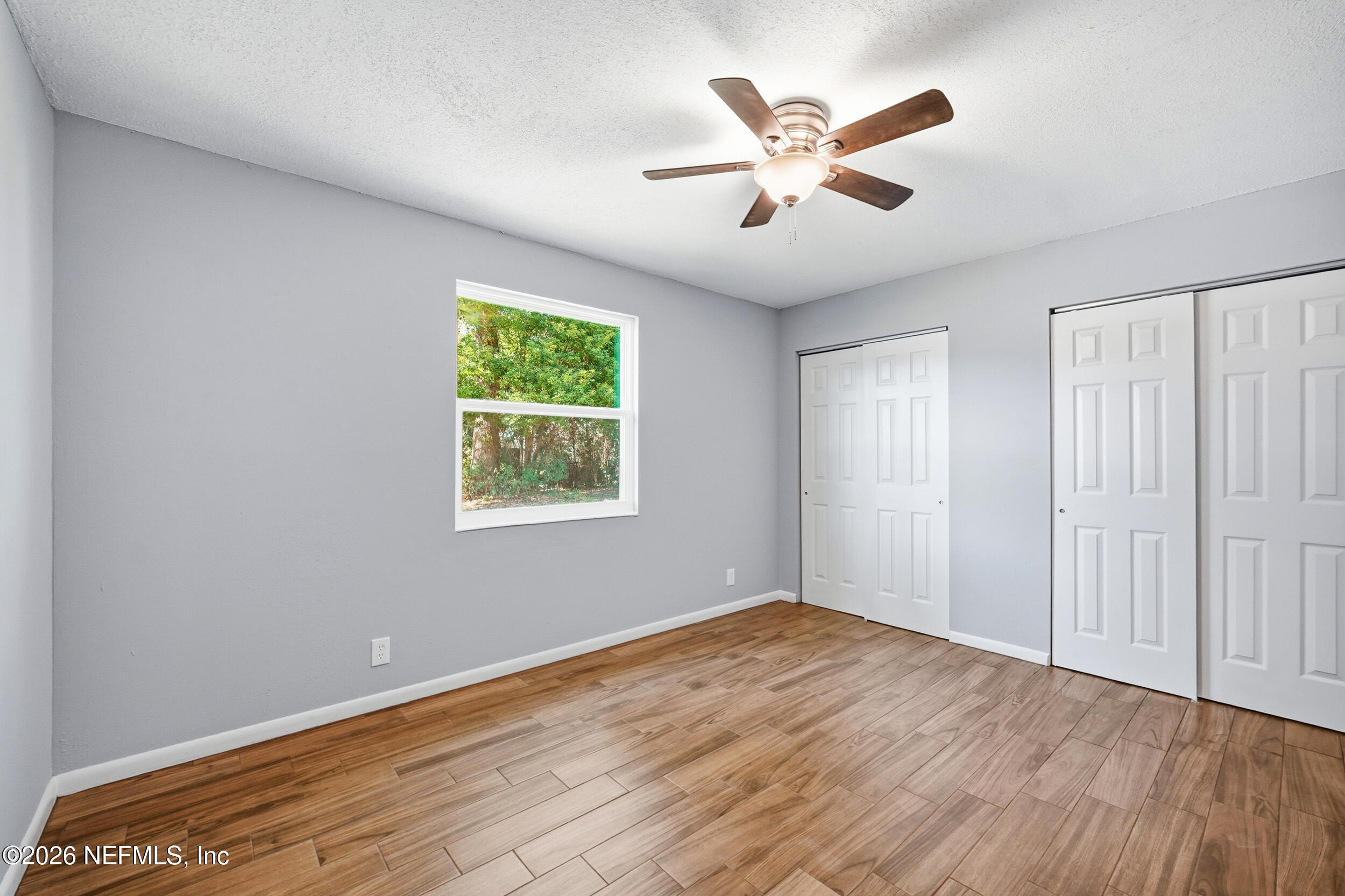 3084 Parental Home Road Jacksonville, FL 32216 - Photo 17 of 31 an empty room with wooden floor fan and windows