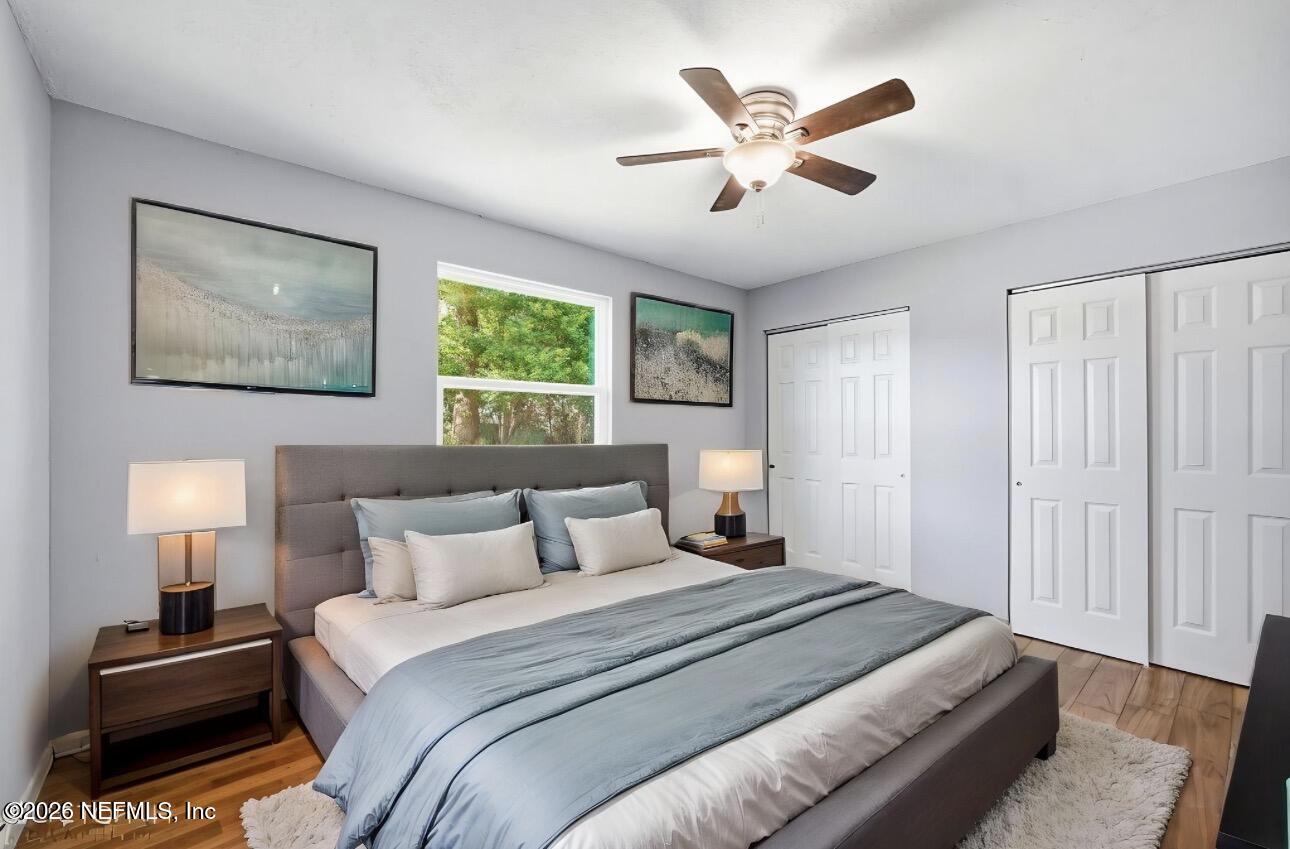 3084 Parental Home Road Jacksonville, FL 32216 - Photo 18 of 31 a bedroom with a large bed and a chandelier