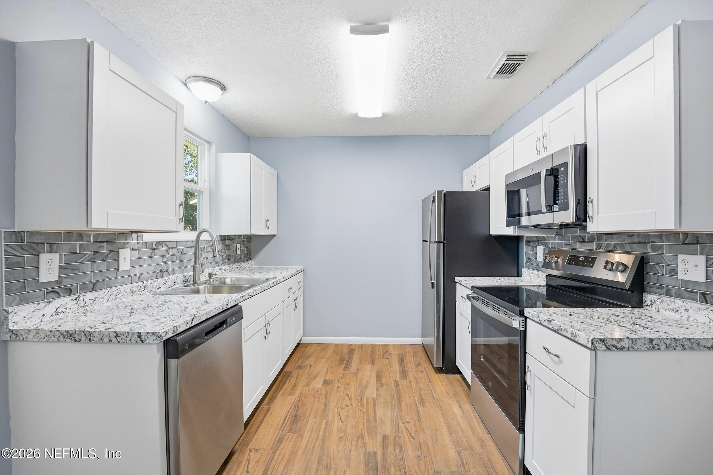 3084 Parental Home Road Jacksonville, FL 32216 - Photo 10 of 31 a kitchen with a sink stove microwave and refrigerator