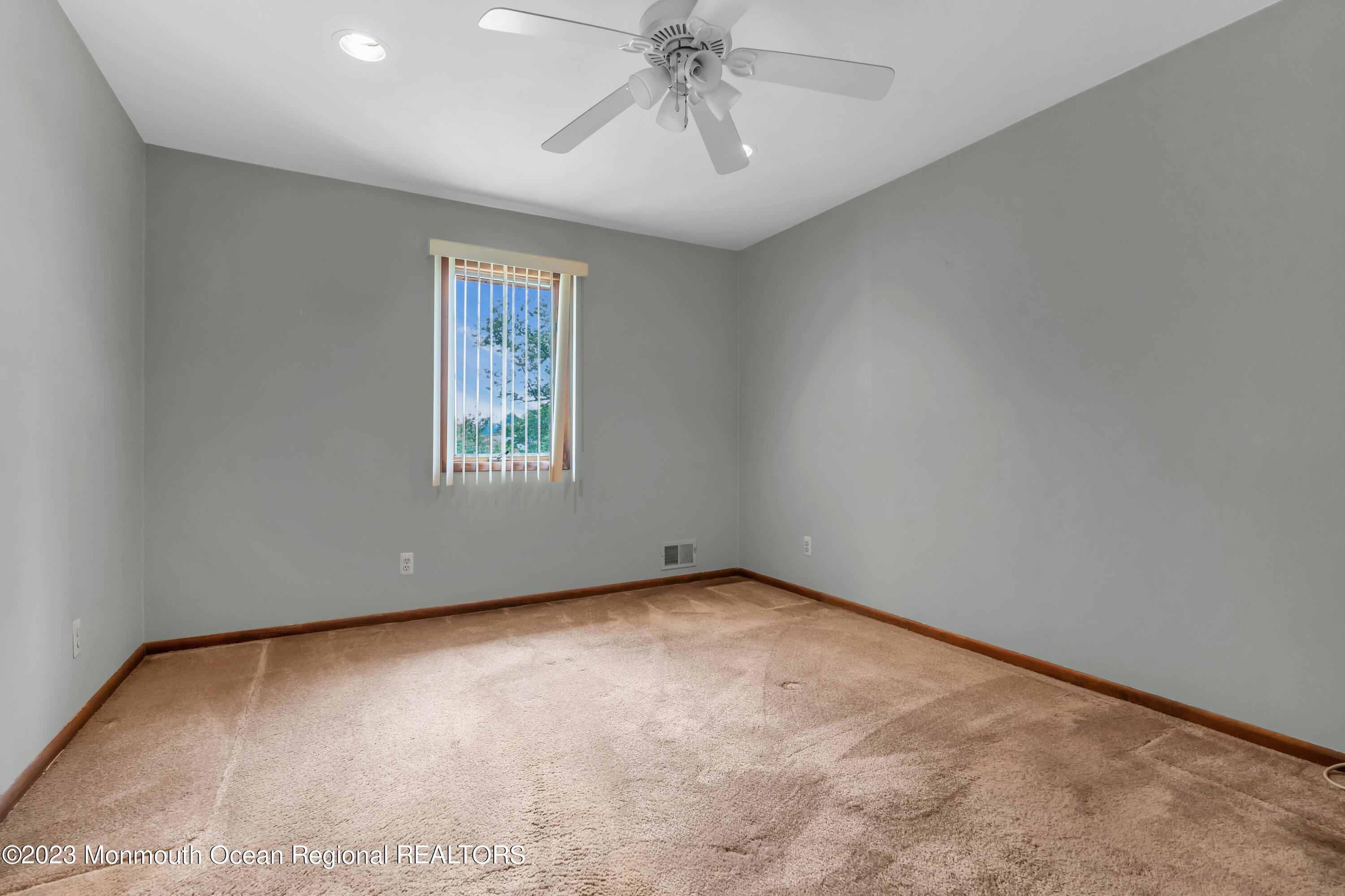 8 Willow Brook Road Freehold, NJ 07728 - Photo 37 of 49 an empty room with a chandelier fan and windows