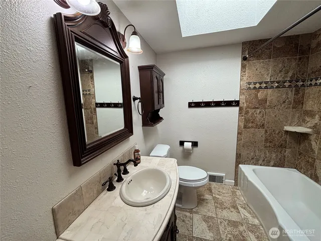 a bathroom with a sink a toilet and bathtub