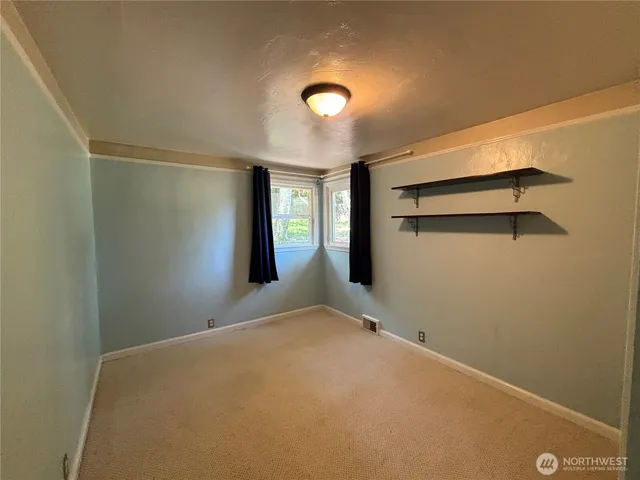 a view of a big room with closet and windows