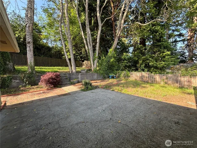 a view of backyard with swimming pool and seating space