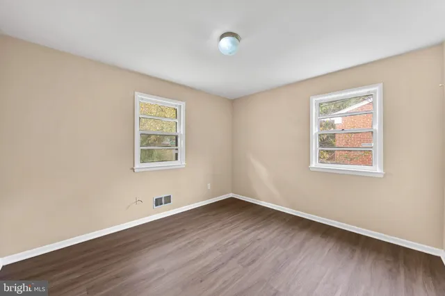 a view of a room with wooden floors and window