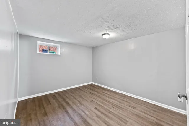 a view of room with wooden floor and white walls