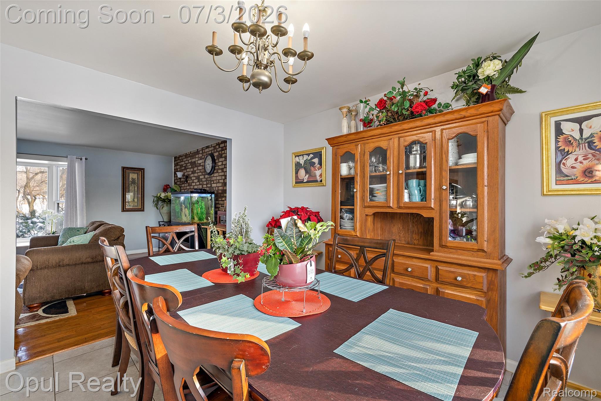 8855 Gross Road Dexter, MI 48130 - Photo 24 of 53 Dining area featuring an oval table with seating for four, an overhead chandelier, and a wood-finish china cabinet with glass-front doors