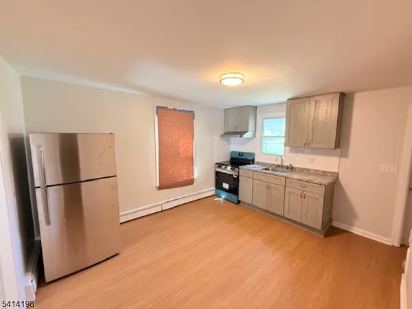 a kitchen with a refrigerator a sink and dishwasher with wooden floor