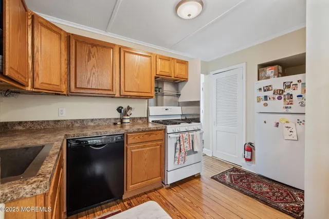 a kitchen with granite countertop a sink cabinets stainless steel appliances and a window