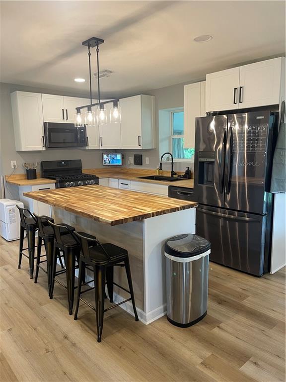 433 Spring Place Resaca Road Chatsworth, GA 30705 - Photo 11 of 51 a kitchen with a refrigerator a sink dishwasher and a stove with wooden floor