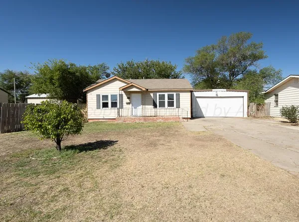 a front view of a house with a garden and yard