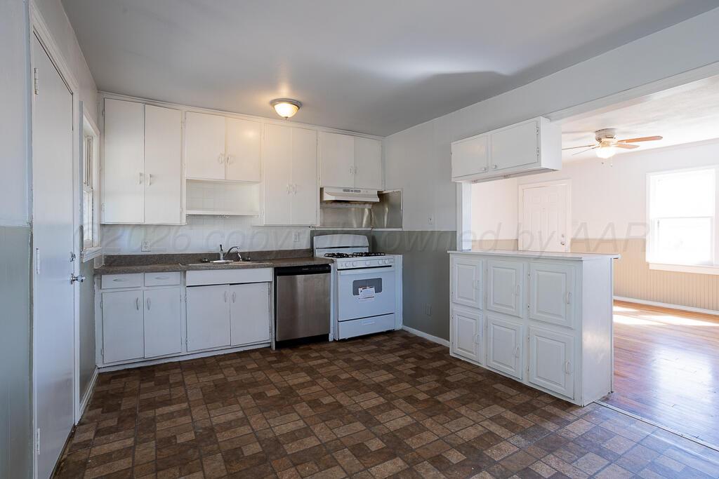 4422 South Ong Street Amarillo, TX 79110 - Photo 5 of 17 a kitchen with granite countertop white cabinets and white appliances