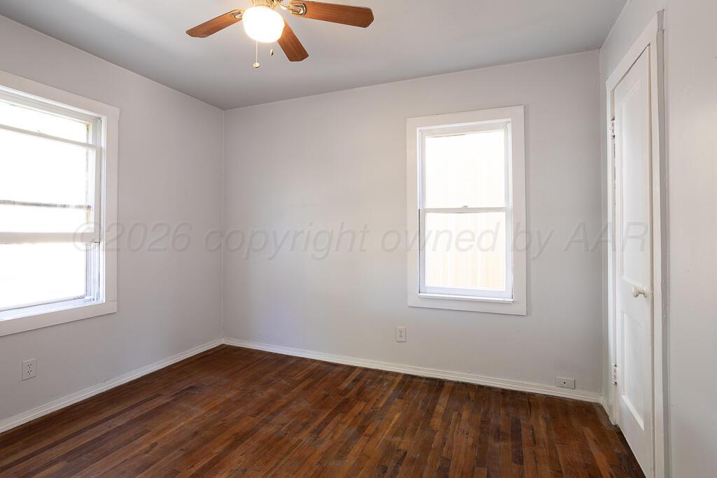 4422 South Ong Street Amarillo, TX 79110 - Photo 8 of 17 an empty room with wooden floor and windows