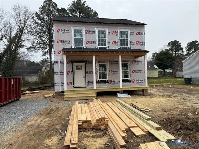 a view of a house with a yard and large tree