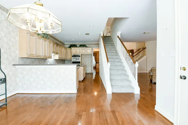 a view of entryway and kitchen with wooden floor