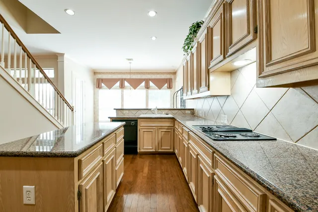 a kitchen with granite countertop a stove and a sink