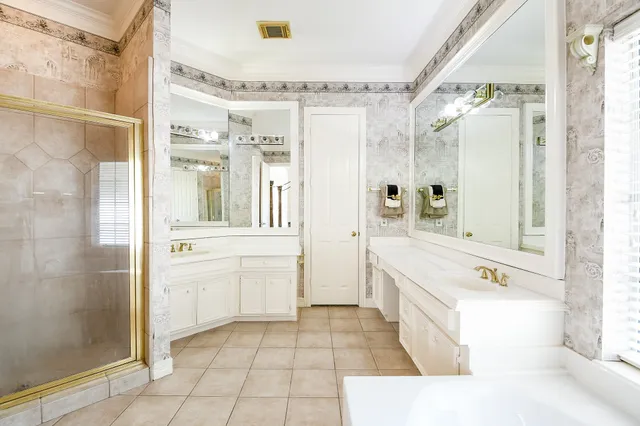 a bathroom with a tub sink shower and mirror