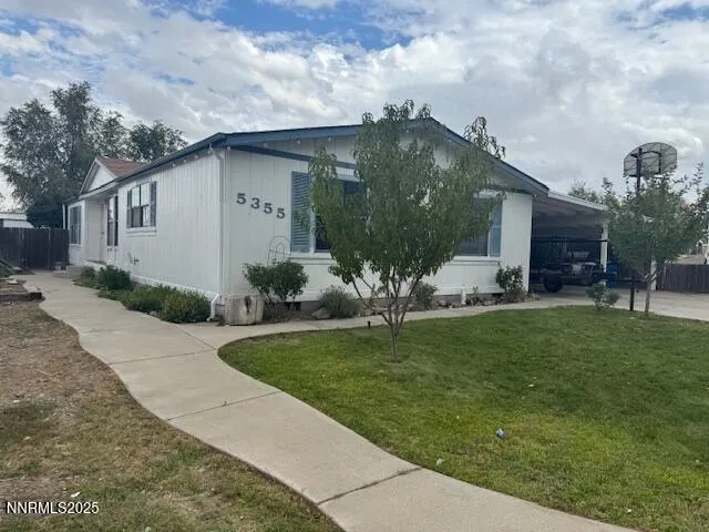 a white house with a yard and table and chairs