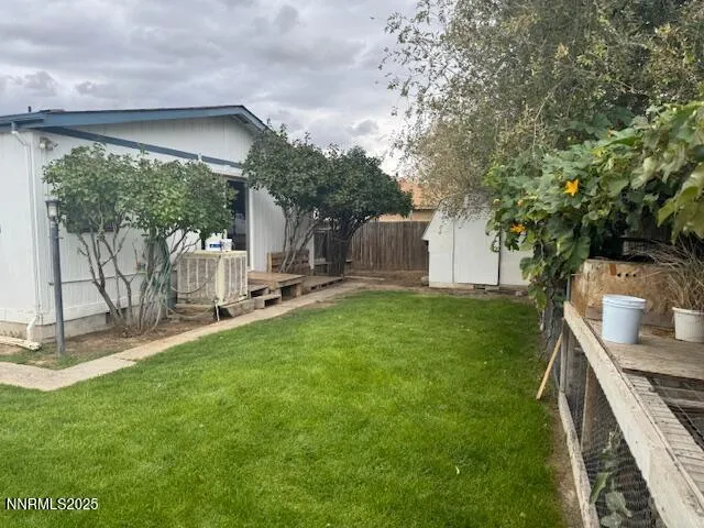 a view of a backyard with table and chairs and a large tree