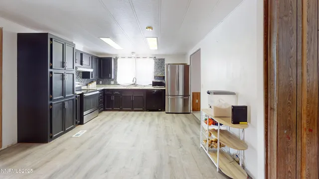 a kitchen with stainless steel appliances granite countertop a refrigerator and a sink