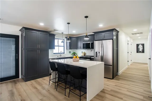 a kitchen with refrigerator and chairs