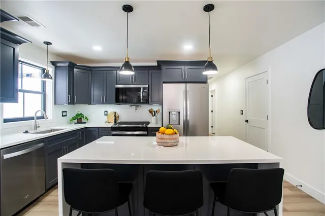 a kitchen with a sink a stove and chairs