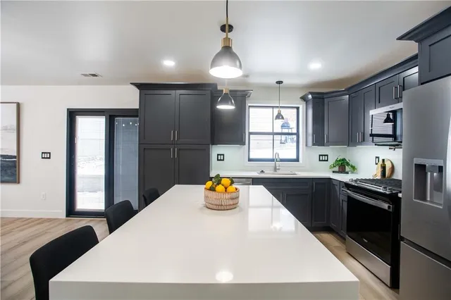 a kitchen with a refrigerator a sink dishwasher stove and refrigerator with wooden floor