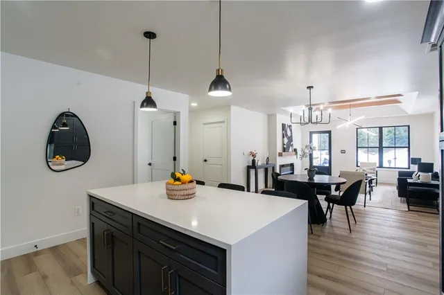 a view of a dining room and livingroom with furniture wooden floor a chandelier