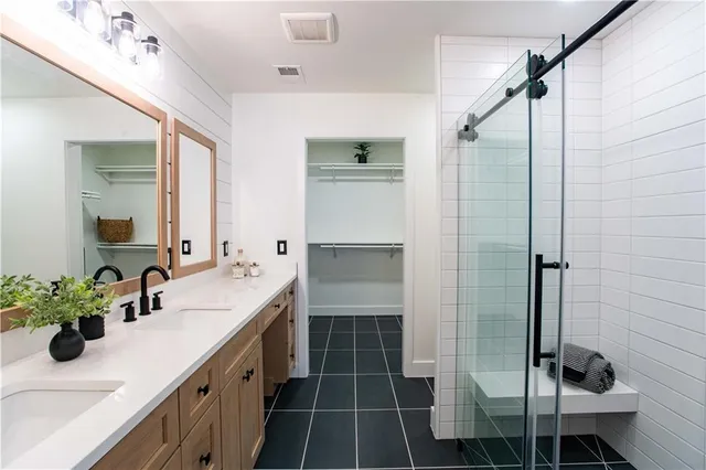 a bathroom with a double vanity sink a mirror and a shower