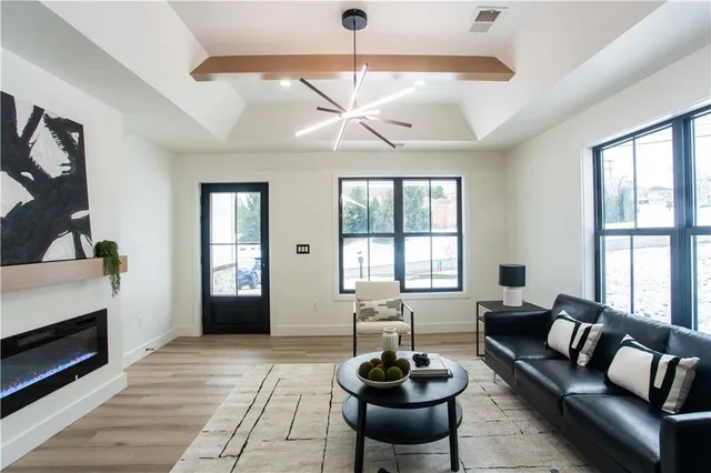 a living room with furniture a chandelier and a window