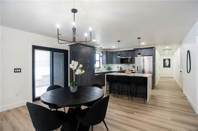 a kitchen with kitchen island a dining table and chairs