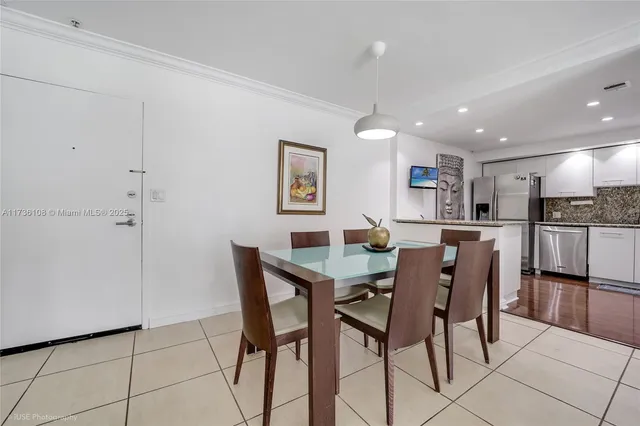 a view of kitchen with refrigerator and chairs