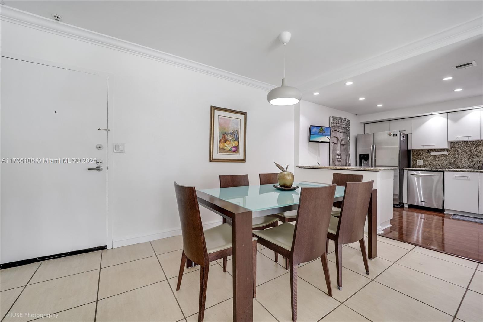 575 Crandon Boulevard, Unit 306 Key Biscayne, FL 33149 - Photo 3 of 18 a view of kitchen with refrigerator and chairs