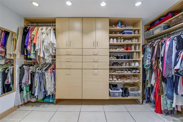 a view of walk in closet with clothes and shoes