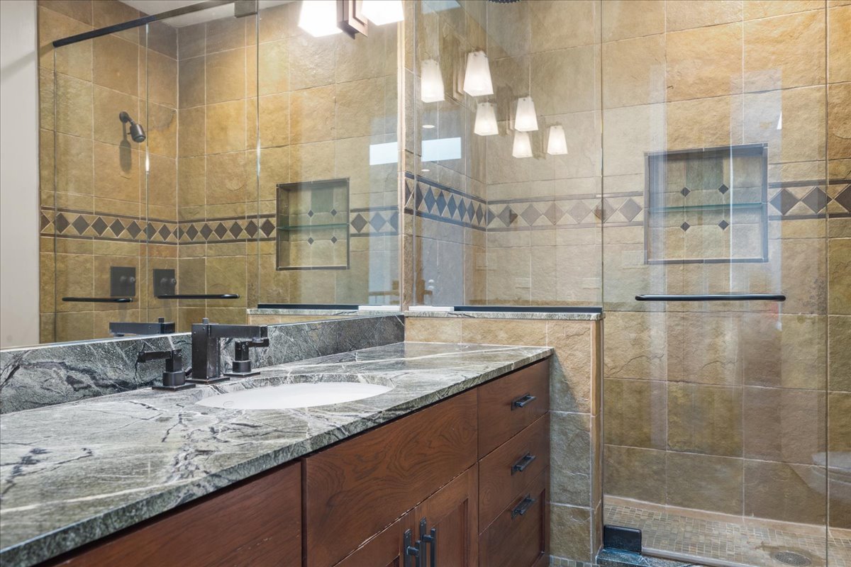 101 Crestview Drive Deerfield, IL 60015 - Photo 25 of 37 a bathroom with a granite countertop sink a mirror and shower