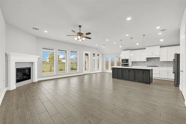 a big room with wooden floors and fireplace