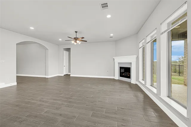 a view of an empty room with a fireplace and a window