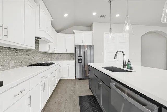 a kitchen with white cabinets appliances and sink