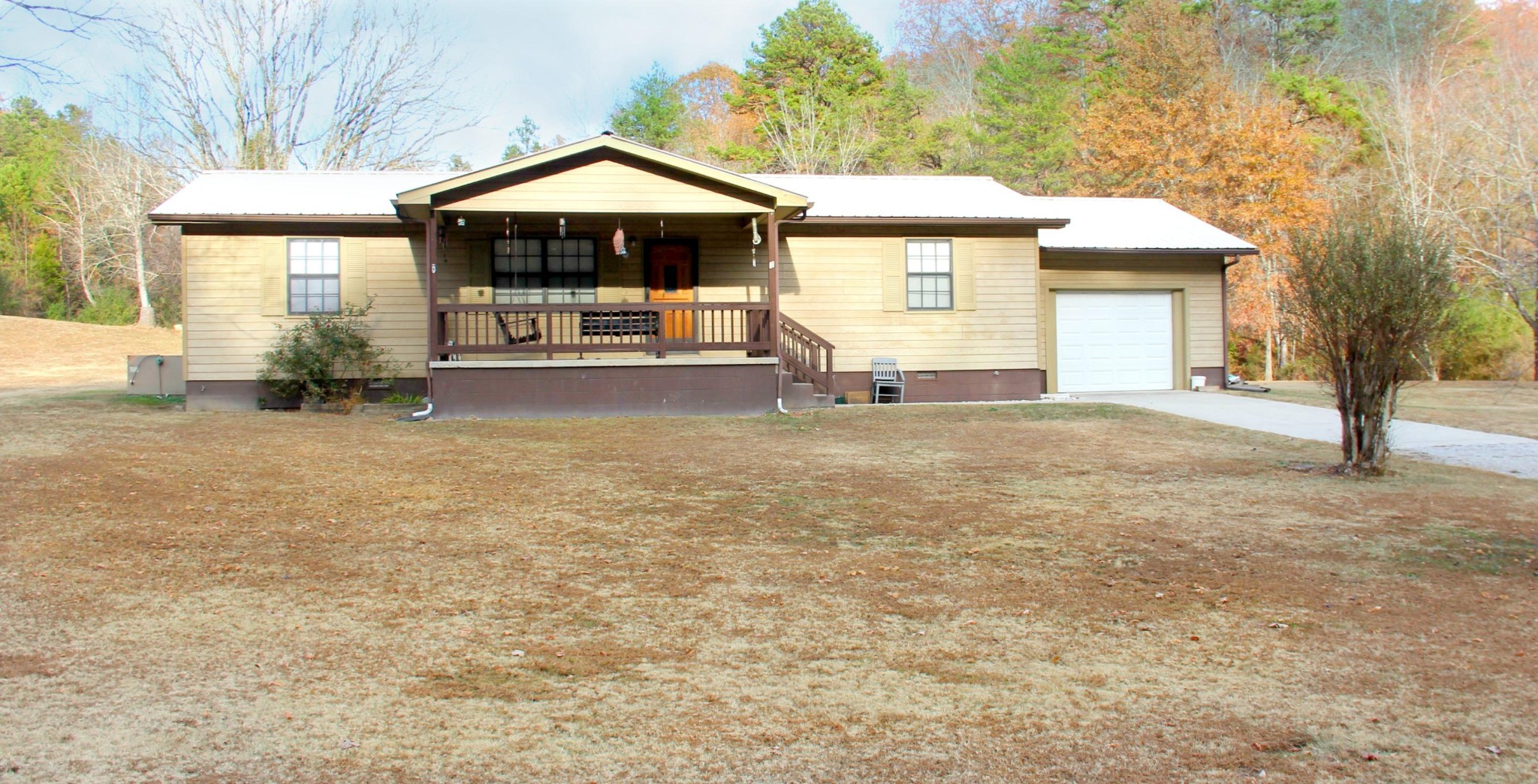 a view of a house with a yard and large tree