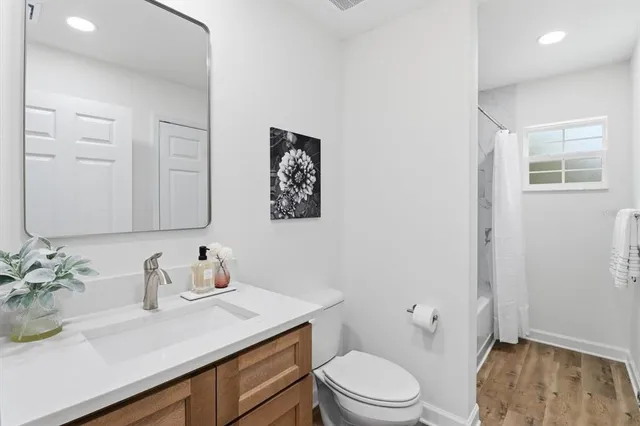 a bathroom with a granite countertop sink mirror vanity and toilet