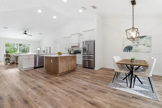 a living room with stainless steel appliances kitchen island granite countertop furniture wooden floor and a kitchen view
