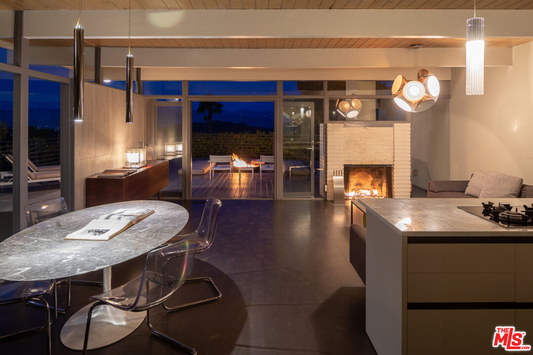 2135 Ridgemont Drive Los Angeles, CA 90046 - Photo 24 of 26 a dining room with furniture and a fireplace