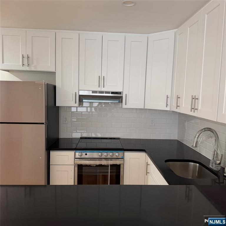 a kitchen with a stove and white cabinets
